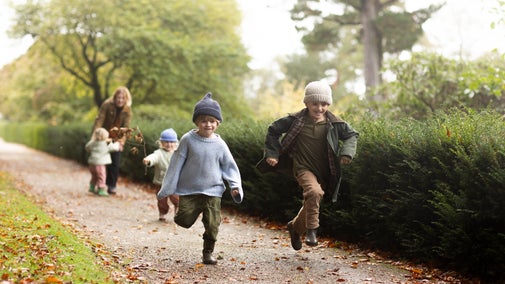 A family exploring the gardens at castle drogo, The two little boys are running ahead of their sister and mother